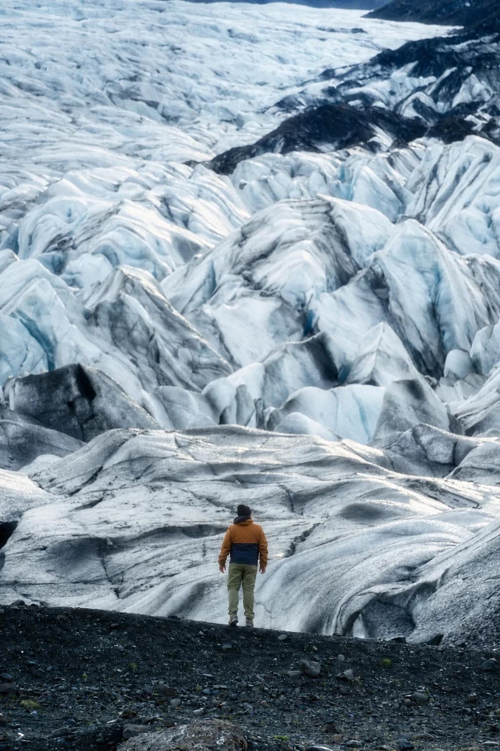 A person standing before a glacier